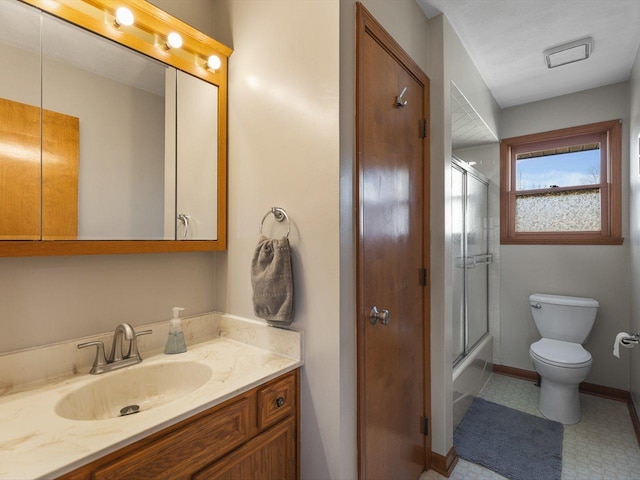 bathroom with tile patterned floors, toilet, shower / bath combination with glass door, baseboards, and vanity