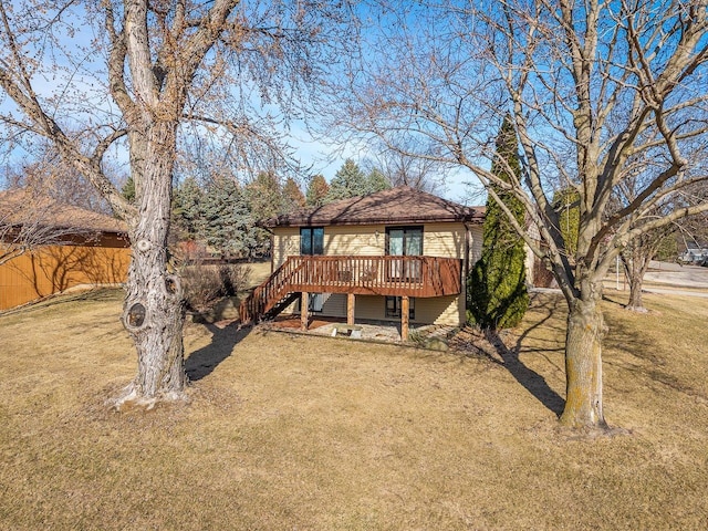 back of house with a wooden deck, stairs, a yard, and fence