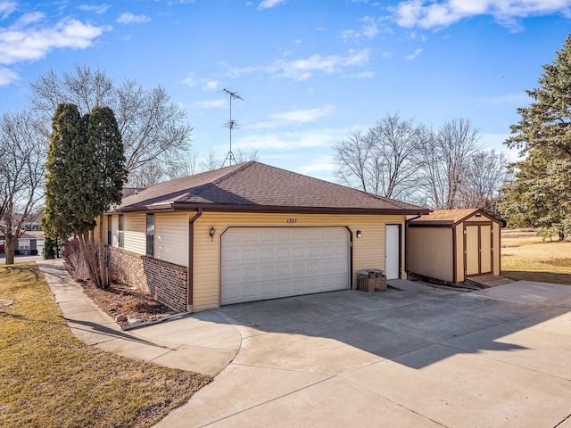 exterior space with an outbuilding, driveway, a shed, roof with shingles, and brick siding