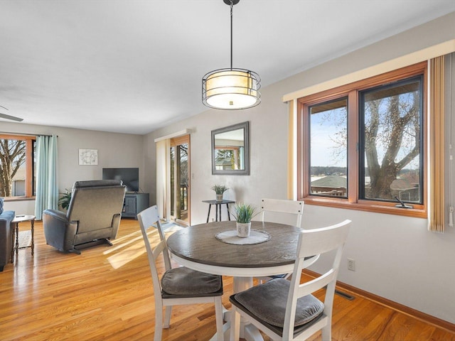 dining space featuring visible vents, baseboards, and light wood finished floors