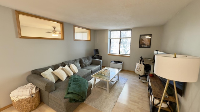 living area featuring baseboards and light wood-style floors