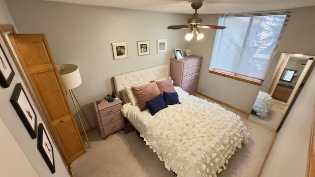 bedroom featuring light colored carpet and a ceiling fan