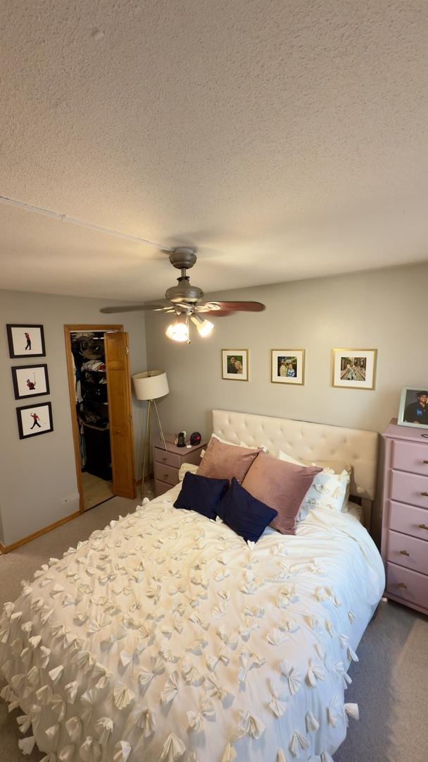 carpeted bedroom featuring a closet, a textured ceiling, and a ceiling fan