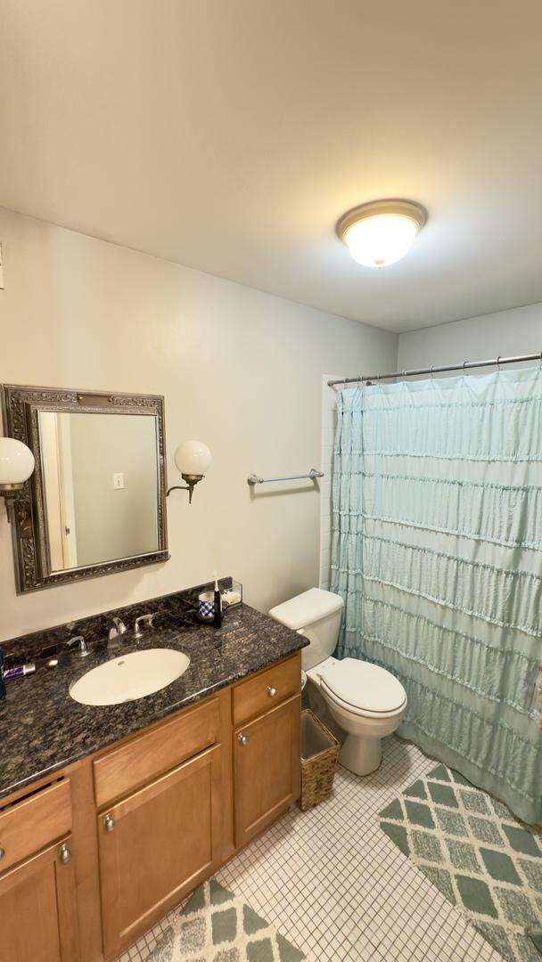 bathroom with tile patterned flooring, toilet, vanity, and a shower with curtain