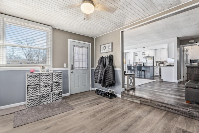 entryway with wood ceiling, a ceiling fan, baseboards, and wood finished floors