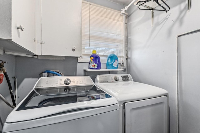 clothes washing area featuring cabinet space and independent washer and dryer