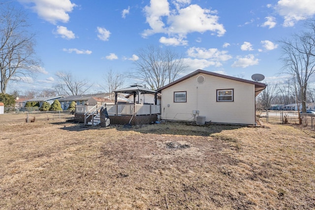 rear view of property featuring a gazebo, central AC unit, fence, and a wooden deck