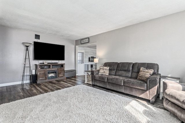 living area featuring dark wood-type flooring and baseboards