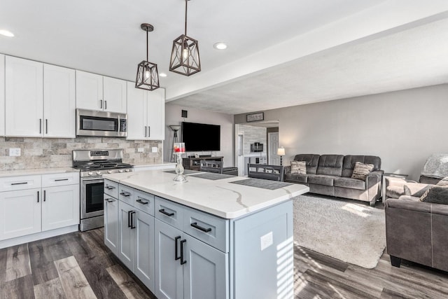 kitchen with dark wood-style floors, stainless steel appliances, open floor plan, tasteful backsplash, and a center island