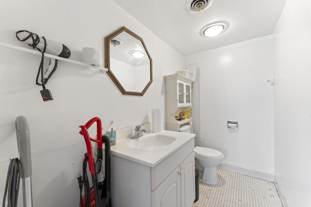 half bath with tile patterned floors, visible vents, toilet, and vanity