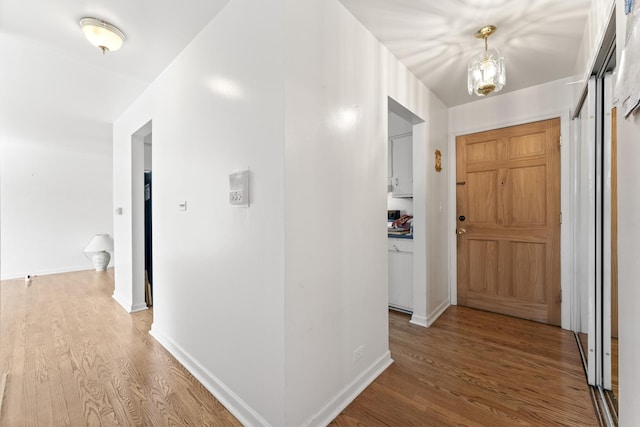 hall featuring baseboards and light wood finished floors