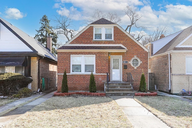 bungalow-style house featuring brick siding and roof with shingles