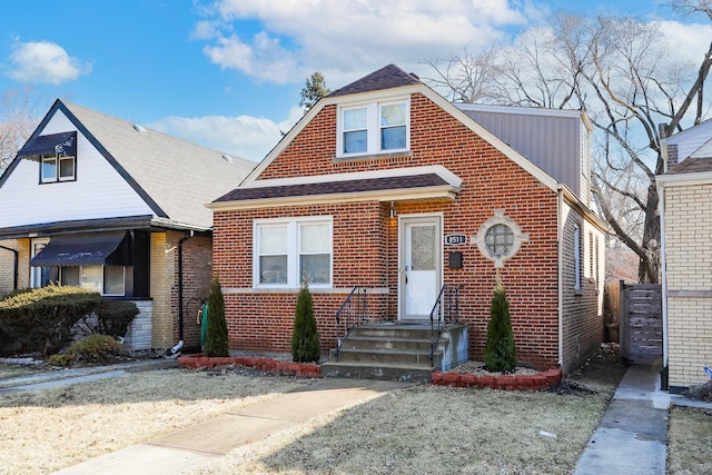 view of front of property with brick siding and a shingled roof