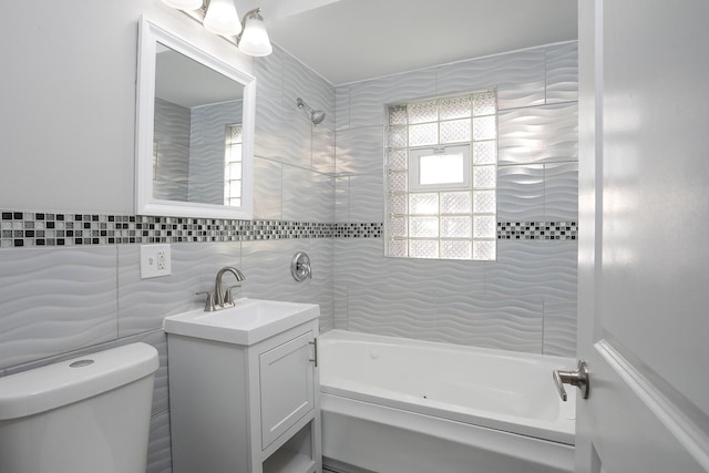 bathroom featuring bathtub / shower combination, tile walls, toilet, and vanity