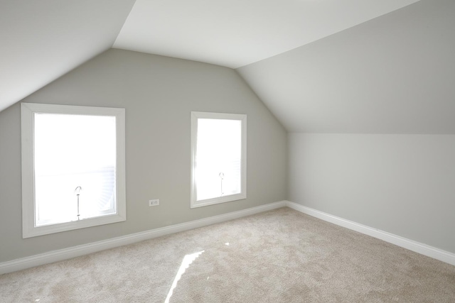 additional living space with lofted ceiling, carpet, and baseboards