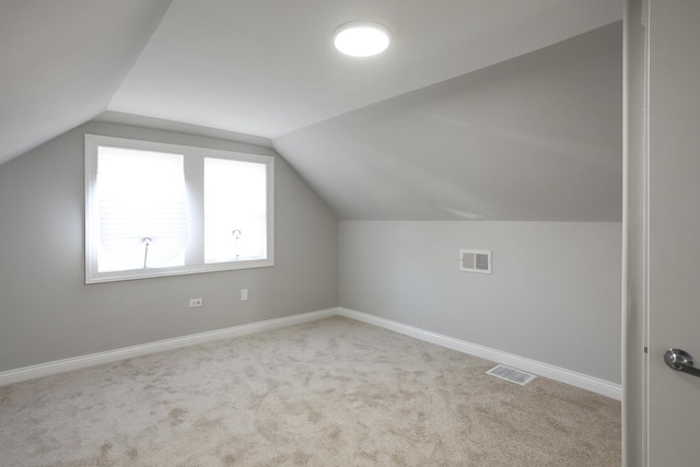 additional living space with visible vents, baseboards, lofted ceiling, and carpet