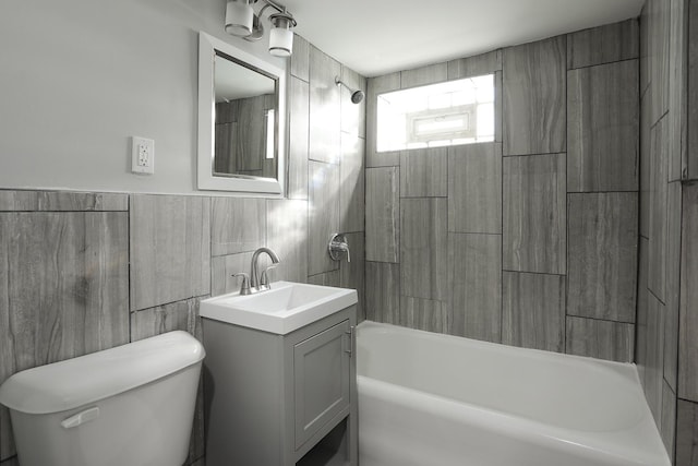 bathroom with vanity, tile walls, toilet, and tub / shower combination