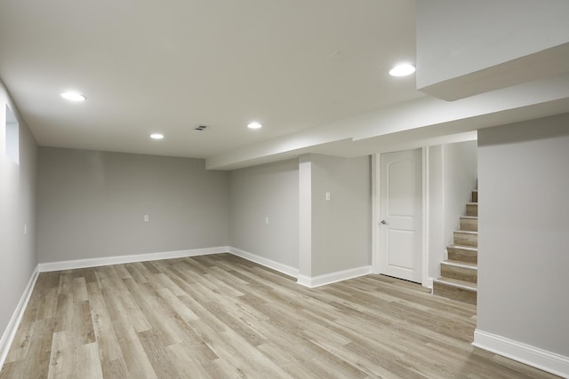 finished basement with recessed lighting, baseboards, and light wood-type flooring