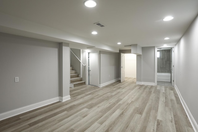 finished basement featuring stairway, visible vents, baseboards, light wood-style flooring, and recessed lighting