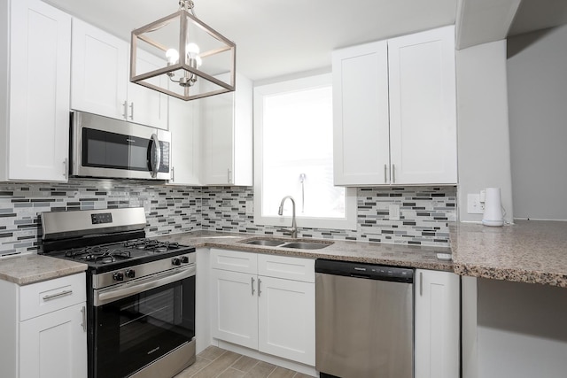 kitchen featuring a sink, tasteful backsplash, appliances with stainless steel finishes, and white cabinets