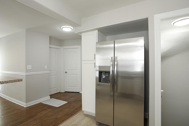 kitchen with baseboards, wood finished floors, stainless steel fridge with ice dispenser, and white cabinets