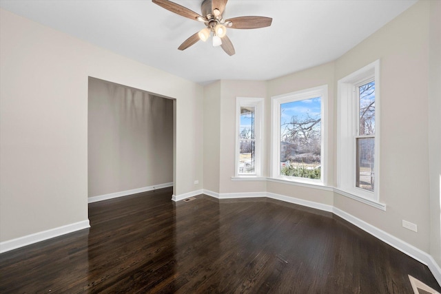 spare room with dark wood-style floors, baseboards, and visible vents