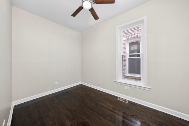 empty room with dark wood-type flooring, baseboards, visible vents, and ceiling fan