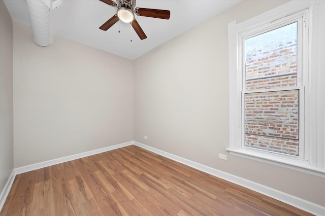 unfurnished room with baseboards, wood finished floors, and a ceiling fan