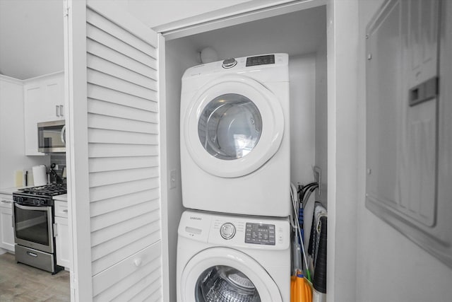 washroom featuring laundry area, stacked washer / dryer, and light wood-style flooring