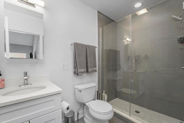 full bath featuring a shower stall, toilet, vanity, and baseboards