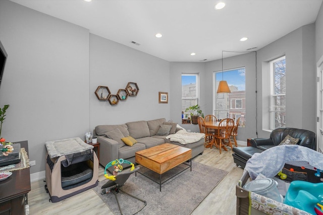 living area with visible vents, light wood-style flooring, recessed lighting, and baseboards