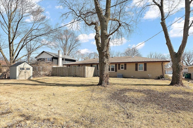 back of property with fence, cooling unit, a storage shed, an outdoor structure, and brick siding