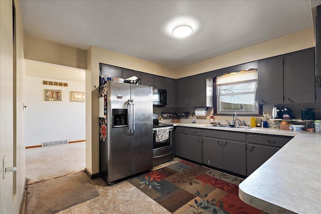 kitchen featuring a sink, visible vents, appliances with stainless steel finishes, and light countertops