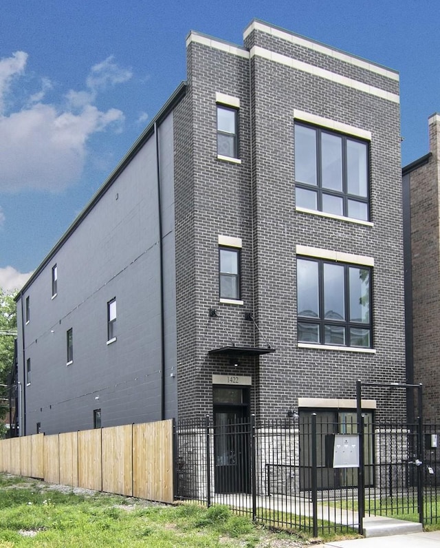 view of front of property featuring fence and brick siding