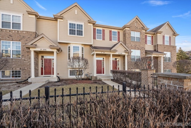 townhome / multi-family property featuring a fenced front yard