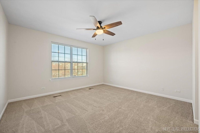 carpeted spare room featuring a ceiling fan, baseboards, and visible vents