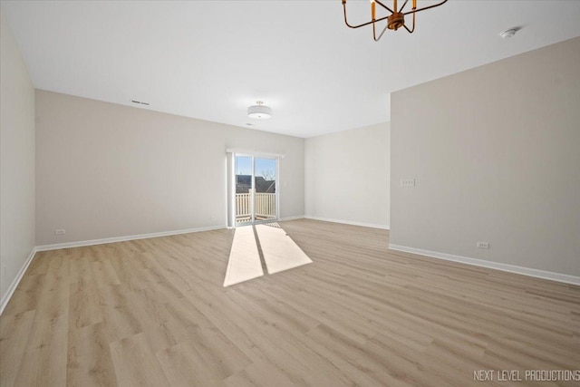 interior space with a notable chandelier, baseboards, and light wood finished floors