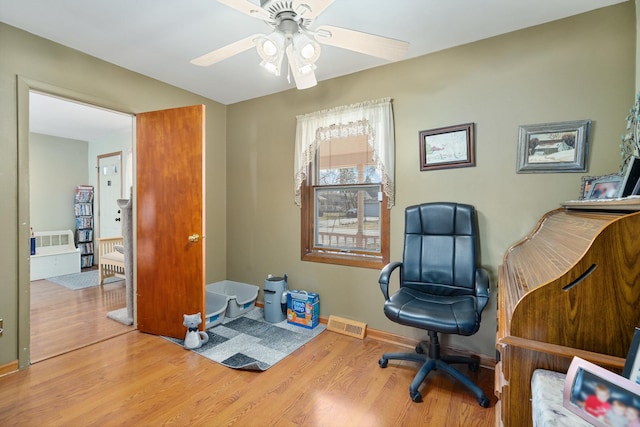 office area featuring visible vents, baseboards, wood finished floors, and a ceiling fan