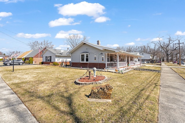 view of side of home featuring a yard, brick siding, and a chimney