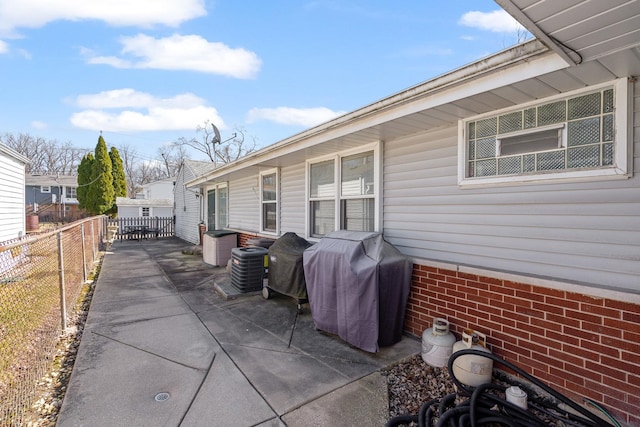 view of patio / terrace with grilling area, central AC, and a fenced backyard