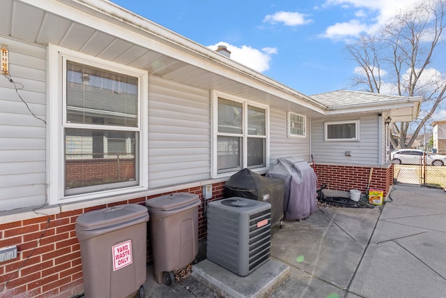 view of patio with area for grilling, central AC, and fence