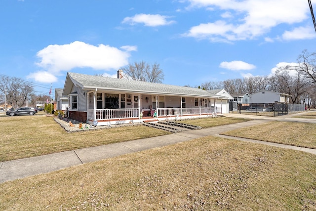 view of front of property with a chimney, roof with shingles, covered porch, and a front lawn