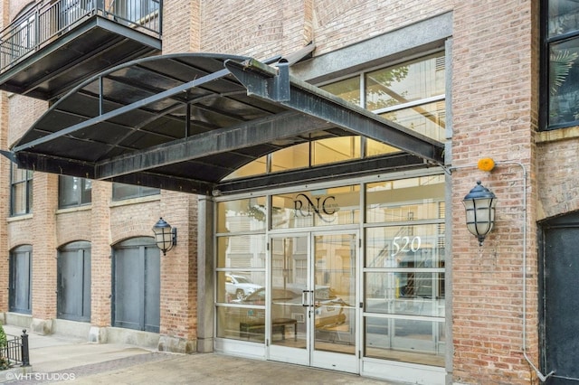 view of exterior entry featuring brick siding