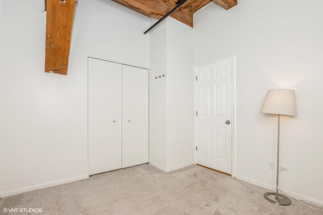unfurnished bedroom featuring baseboards, carpet flooring, and a closet