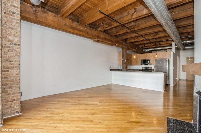 unfurnished living room featuring beamed ceiling, wooden ceiling, and wood finished floors