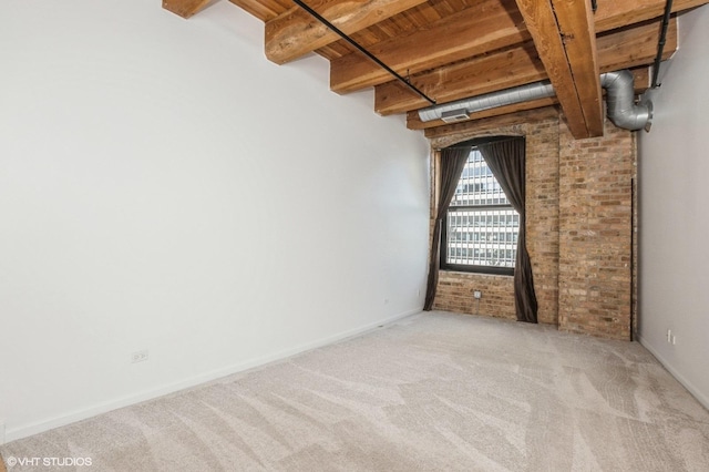 carpeted empty room featuring visible vents, beamed ceiling, brick wall, wood ceiling, and baseboards