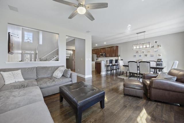 living area featuring baseboards, ceiling fan, dark wood finished floors, stairs, and recessed lighting