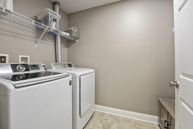 laundry room with laundry area, washing machine and dryer, and baseboards