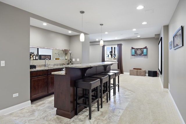 bar with hanging light fixtures, recessed lighting, baseboards, and a sink