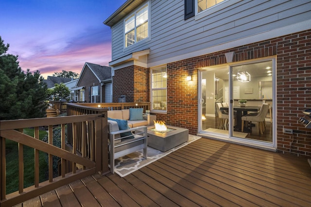 deck at dusk featuring a fire pit